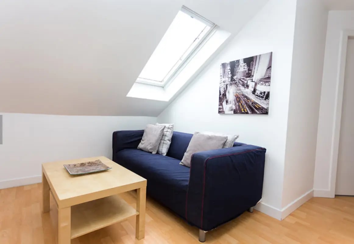 Blue sofa light wood table artwork skylight living room at King Street 207 in Aberdeen Student Accommodation